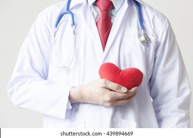 Doctor Showing Compassion And Support Holding Red Heart Onto His Chest In Coat