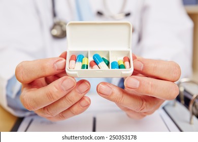 Doctor Showing Pill Dispenser Filled With Medication In His Hands