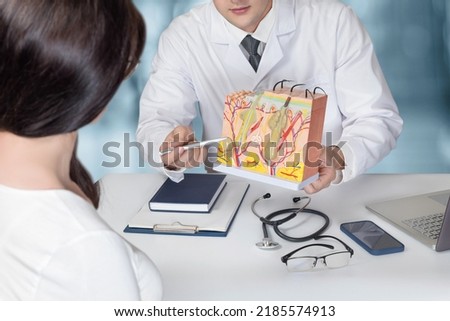 Doctor showing skin anatomy model to patients in office.