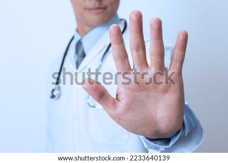 Doctor  showing stop sign on white background