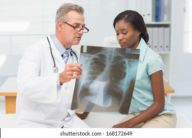 Doctor Showing Young Patient Her Chest Xray In His Office At The Hospital