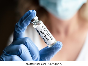 Doctor shows bottle with COVID19 vaccine in laboratory. Coronavirus vaccine vial for COVID cure close-up. Concept of vaccination, omicron, technology, health, vaccine trial and distribution.