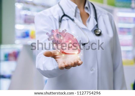 Doctor shows heart in his hand . The concept of treatment of the cardiovascular system.