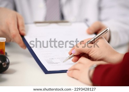 Doctor shows patient tablet with documents in clinic closeup