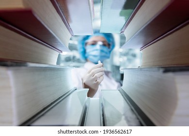 Doctor Shows A Pill For Treatment In Front Of Medical Textbooks.