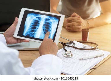 Doctor shows results to old patient x-ray of the lungs, smoking cigarettes problem - Powered by Shutterstock