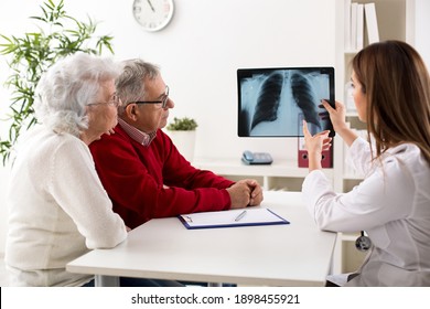 Doctor shows results to old patient x-ray of the lungs at clinic - Powered by Shutterstock