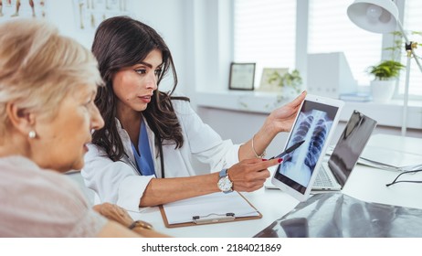 Doctor shows results to old patient x-ray of the lungs, smoking cigarettes problem. Doctor explaining lungs x-ray on Tablet PC screen to young patient. Doctor showing female patient x-ray shot  - Powered by Shutterstock