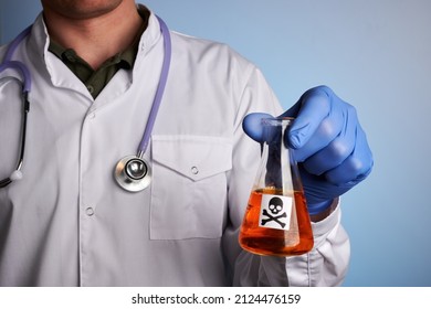 Doctor shows retort with toxic orange drink - labs photo. Chemical flask with poisoned orange juice. Fake orange juice for science test. Search of GMO substances inside colorful drinks. Toxic liquid.