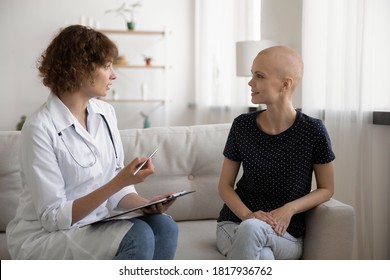 Doctor sit on sofa at home or hospital talk consult young Caucasian hairless sick woman suffer from oncology. Nurse speak with bald female patient struggling with cancer, healthcare. Medicine concept.