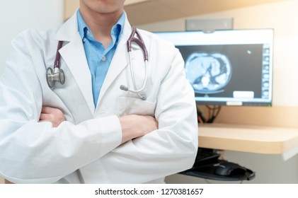 A Doctor Sitting In Front Of Computer Screen And Abdominal CT Scan Image In The Back Ground 