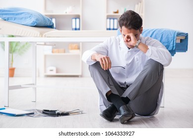 Doctor Sitting On The Floor In Hospital