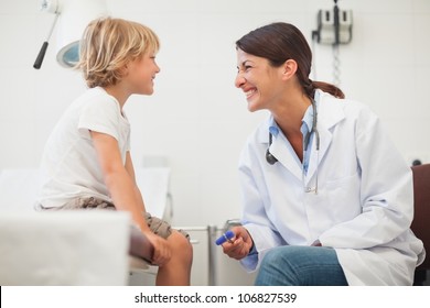 Doctor Smiling To A Child In Examination Room