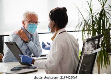 Doctor Specialist Consulting A Patient In A Doctor's Office At A Clinic. Female Doctor Is Talking With A Male Elderly Patient