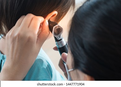 Doctor Specialist For Ear Is Looking Inside Kid Ear.