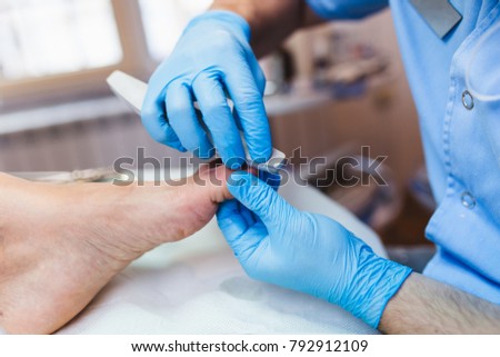 Doctor specialist giving pedicure treatment to his patient