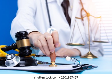 Doctor Stamp Approval With Authority To Patient To Death. Law Legal Protect Medical Doctor From Criminal Court Judgement. Concept With Stethoscope Balance Scale Mullet Hammer, Copy Space