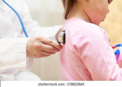 Doctor With Stethoscope Examining A Child Girl In A Hospital