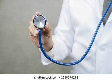 Doctor with a stethoscope in the hands on gray background .