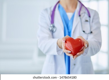 Doctor with stethoscope holding heart, isolated on white background - Powered by Shutterstock