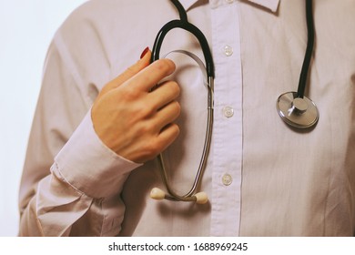 doctor with a stethoscope on hospital background. A doctor in a white coat with a stethoscope. coronavirus treatment. A doctor in a white coat holds a stethoscope in his hands.vintage photo processing - Shutterstock ID 1688969245