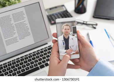 Doctor with a stethoscope on the smartphone screen. Telemedicine or telehealth concept. - Shutterstock ID 1306730191