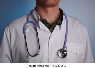 Doctor and stethoscope in white dress  Medic guy in white costume   medical tool the neck  Physician stays before sky blue gradient background  Photo is taken for medical ads  Usual doctor for