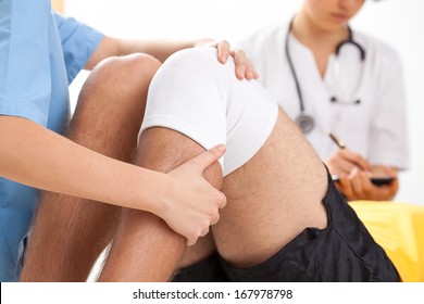 Doctor supervising the recovery of his patient after knee surgery
