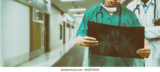 Doctor And Surgeon Examining Xray Film, Diagnose Patient 's Waist Bone Injury For Surgeoning Treatment. Surgeon Operation And Medical Banner Design.