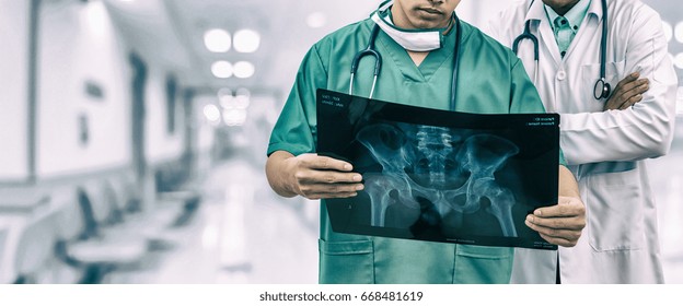 Doctor And Surgeon Examining Xray Film, Diagnose Patient 's Waist Bone Injury. Surgery Operation And Medical Banner Design.