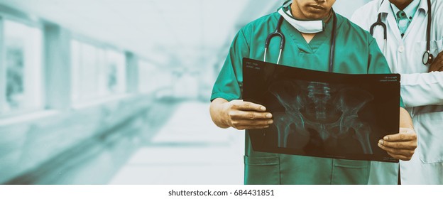 Doctor And Surgeon Examining Xray Film, Diagnose Patient 's Waist Bone Injury. Surgery Operation And Medical Banner Design.