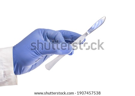 Doctor surgeon holds a scalpel in his hand on a white background. Surgical concept, instrument