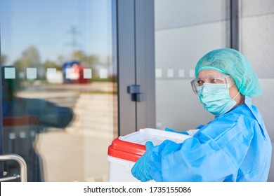 Doctor Or Surgeon With Organ Transport After Organ Donation For Operation In Front Of The Clinic Entrance In Protective Clothing