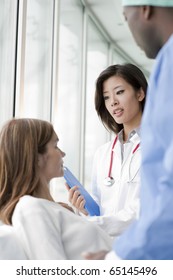 Doctor And Surgeon Speaking With A Female Patient