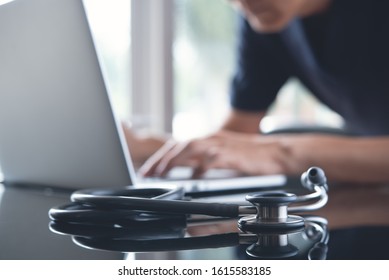 Doctor, Surgeon Working On Laptop Computer In Medical Workspace Office With Stethoscope On Desk, Close Up. Doctor Searching Information On Digital Document, Electronic Health Record System Concept