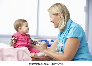 Doctor In Surgery Examining Baby Girl