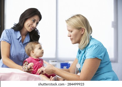 Doctor In Surgery Giving Baby Girl Injection