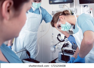 Doctor in surgery of hospital performing colonoscopy at sedated patient