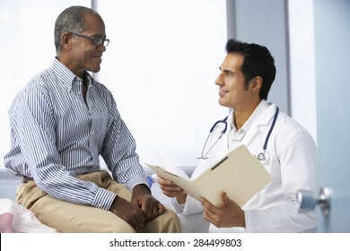 Doctor In Surgery With Male Patient Reading Notes - Powered by Shutterstock