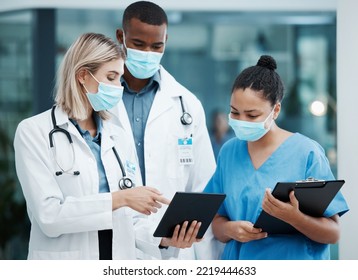 Doctor, Tablet And Covid Team For Healthcare, Research Or Diagnosis In Collaboration Together At The Hospital. Diverse Group Of Medical Professionals Wearing Masks Looking At Touchscreen In Clinic