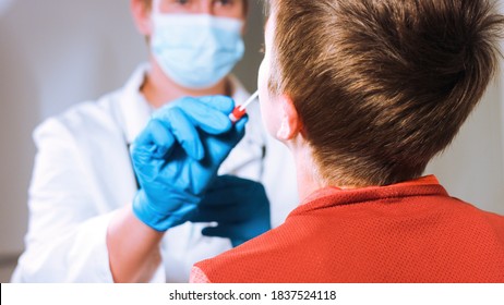 Doctor takes a cotton swab coronavirus test from child nose to analyse if postitve for covid-19. - Shutterstock ID 1837524118