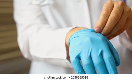 Doctor Takes Off Gloves. A Man Doctor Takes Off Her Protective Gloves After Working Day.