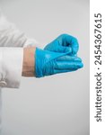 Doctor takes off latex gloves on a white background. Vertical photo. 