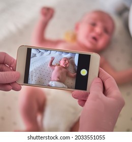 The Doctor Takes A Video On The Phone With A Newborn Baby. A Nurse Holds An Online Conference On The Treatment Of A Child