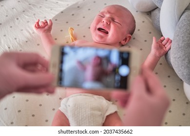 The Doctor Takes A Video On The Phone With A Newborn Baby. A Nurse Holds An Online Conference On The Treatment Of A Child