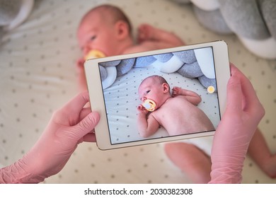 The Doctor Takes A Video On A Tablet With A Newborn Baby. A Nurse Conducts An Online Consultation On The Treatment Of A Child