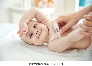 Doctor taking baby's temperature, close up