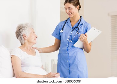Doctor taking care of suffering senior patient at home - Shutterstock ID 388036009