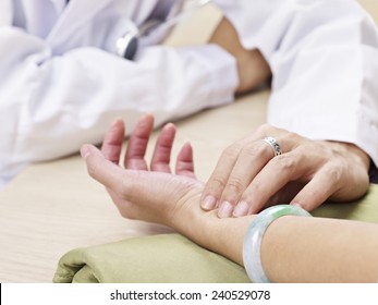 Doctor Taking A Female Patient's Pulse.