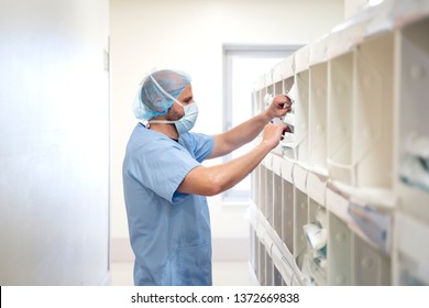 Doctor taking medication from a bookshelf. - Shutterstock ID 1372669838